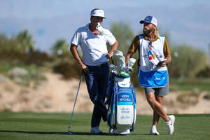 Keith Mitchell Enjoying A Moment With His Caddie Wallpaper