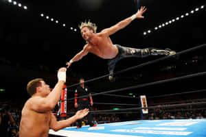 Kenny Omega Swan Diving Towards Cody Rhodes Wallpaper