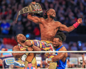 Kofi Kingston Celebrating Victory With The New Day Teammates Wallpaper