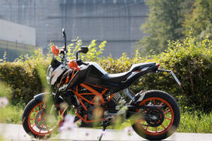 Ktm Duke 200 Parked Near A Bush Wallpaper