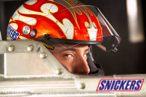 Kyle Busch Posed With The Snickers Logo On His Racing Gear. Wallpaper