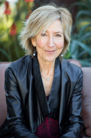 Lin Shaye On Brown Couch Wallpaper