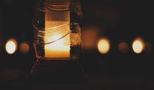 Lit Candle Inside Bottle Dim Wallpaper