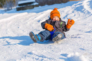 Little Boy Sledding Slide Wallpaper