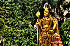 Lord Murugan Statue Surrounded By Trees Wallpaper