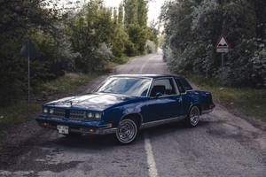 Lowrider Oldsmobile In Forest Wallpaper