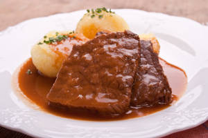 Luscious Sauerbraten Traditional German Dish With Potato Dumplings Wallpaper