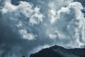 Magnificent Cumulonimbus Clouds Over Majestic Mountain Wallpaper