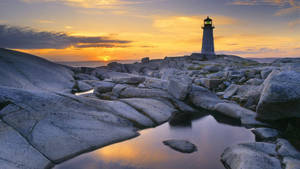 Majestic Lighthouse Illuminating The Shoreline Wallpaper