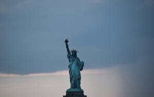 Majestic Statue Of Liberty Against A Gray Sky Wallpaper