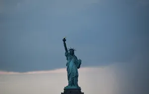 Majestic Statue Of Liberty Against A Gray Sky Wallpaper