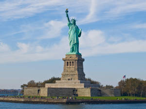 Majestic View Of The Statue Of Liberty At Sunset Wallpaper