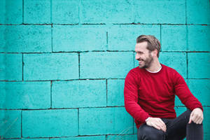 Male Pose Against Blue Brick Wall Wallpaper