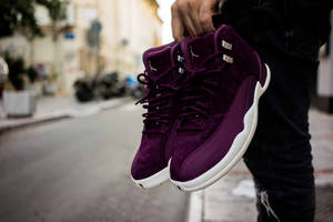 Man Holding Purple Sneakers Wallpaper