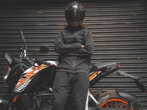 Man Leaning On A Ktm Duke 200 Wallpaper