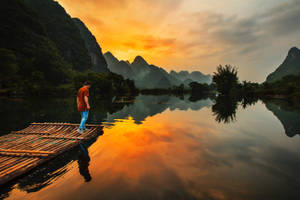 Man On A Raft By The Riverside Wallpaper