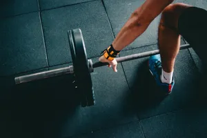 Man Picking Up A Fitness Barbell Wallpaper