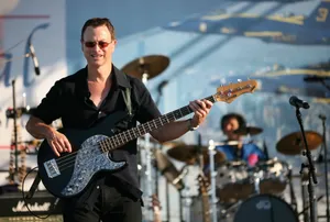 Man Playing Bass Guitar Outdoor Concert Wallpaper