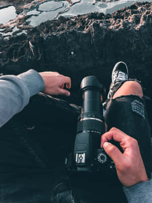 Man Sitting On Cliff With Photography Camera Wallpaper