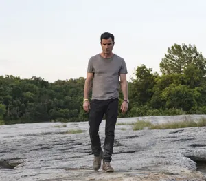 Man Standingon Rocky Terrain Wallpaper