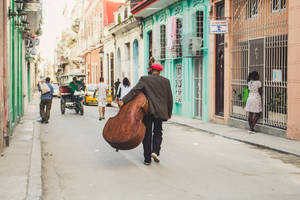 Man With Guitar Case In Cuba Wallpaper