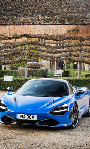 Mclaren 720s Blue Car In Garden Phone Wallpaper