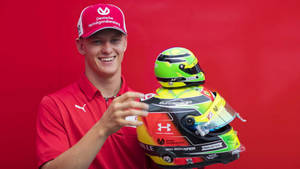 Mick Schumacher Holding Miniature Helmet Wallpaper