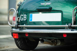 Mini Cooper Logo On The Back Of A Green Mini Cooper Vehicle Wallpaper