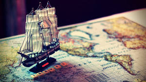Miniature Ship On World Map Wallpaper