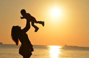 Mom And Son By The Beach Wallpaper