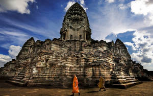 Monks Walking By Ruins Of Angkor Wat Wallpaper