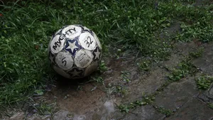 Muddy Football In Grass Wallpaper