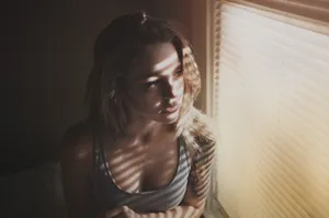 Mujer Soltera Looking Outside The Window Wallpaper