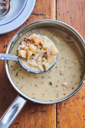 New England Clam Chowder Soup In Silverware Scoop Wallpaper