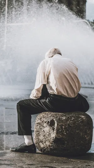 Old Man Back Sitting On Large Rock Wallpaper