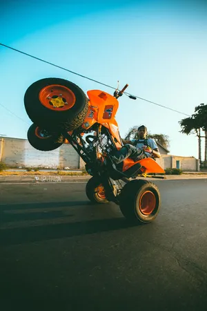 Orange A T V Wheelie Stunt Wallpaper