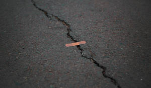 Orange Band Aid On Concrete Surface Crack Wallpaper