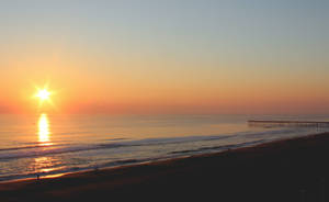 Orange Sun Rising Above Virginia Beach Wallpaper