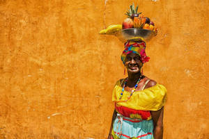 Palenquera Lady Carrying Fruit Basket In Colombia Wallpaper