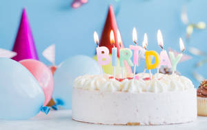 Pastel White Birthday Cake With Lit Candles Wallpaper