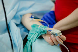 Patient Receiving Iv Drip Treatment In A Hospital Wallpaper