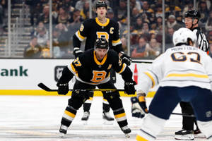 Patrice Bergeron In Action During A Game Against Buffalo Sabres Wallpaper