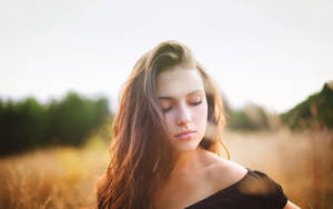 Peaceful Mature Woman Enjoying Nature Near Tall Grass Wallpaper