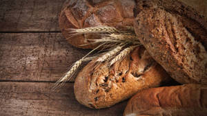 Perfectly Toasted Bread With Raw Wheat Spikes Wallpaper