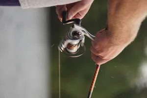 Person Steering Fishing Rod Wallpaper