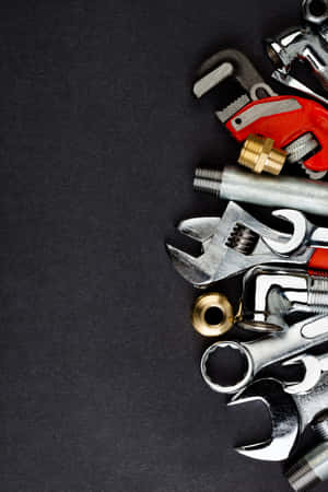 Plumbing Tools On Textured Black Background Wallpaper