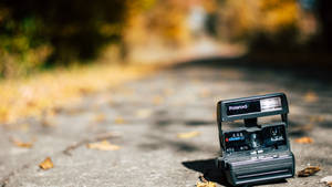 Polaroid Camera On The Road Wallpaper