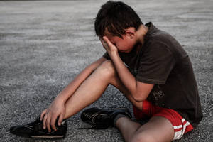 Portrait Of A Tearful Young Boy Displaying Emotion Wallpaper