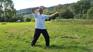 Practicing Tai Chi In A Serene Open Field Wallpaper