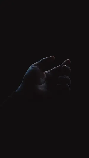 Pristine Oled Display In Hand In Dark Room Wallpaper